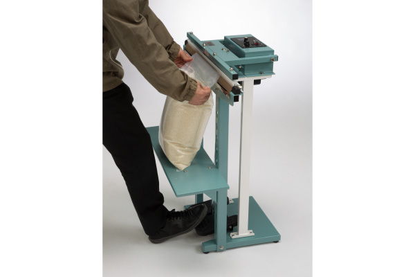 Insert the bag between the sealing bars and press down on the foot board.
